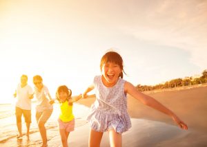 A happy family with picture perfect smiles on vacation at the beach.
