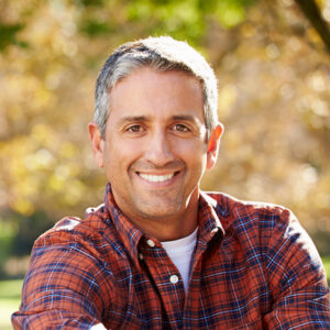 A mature man smiling with confidence thanks to restorative dentistry.