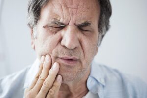 A man clutching his jaw in pain from a dental emergency in Lansdale.