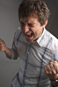 A man cringing in pain from an untreated dental infection.