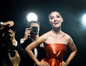 A young woman smiling in front of photographers after porcelain veneers in Hatfield.